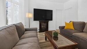 A modern living room with two sofas, a coffee table, a flat-screen TV, and a lamp. - Perfect Location! Perfect Stay in Québec City! Suite Belle (Québec)