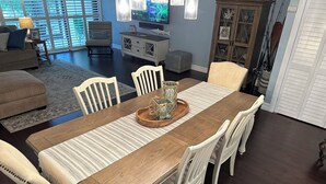 A dining area with a wooden table, white chairs, and a striped rug. - Charming Florida Keys townhome with boat slip in Tavernier 3 bedrooms available (Tavernier)