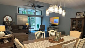A dining area with a wooden table, white chairs, and a ceiling fan. - Charming Florida Keys townhome with boat slip in Tavernier 3 bedrooms available (Tavernier)