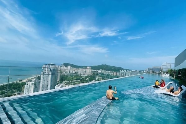 Piscina infinita en la azotea con vistas a la ciudad y al océano.