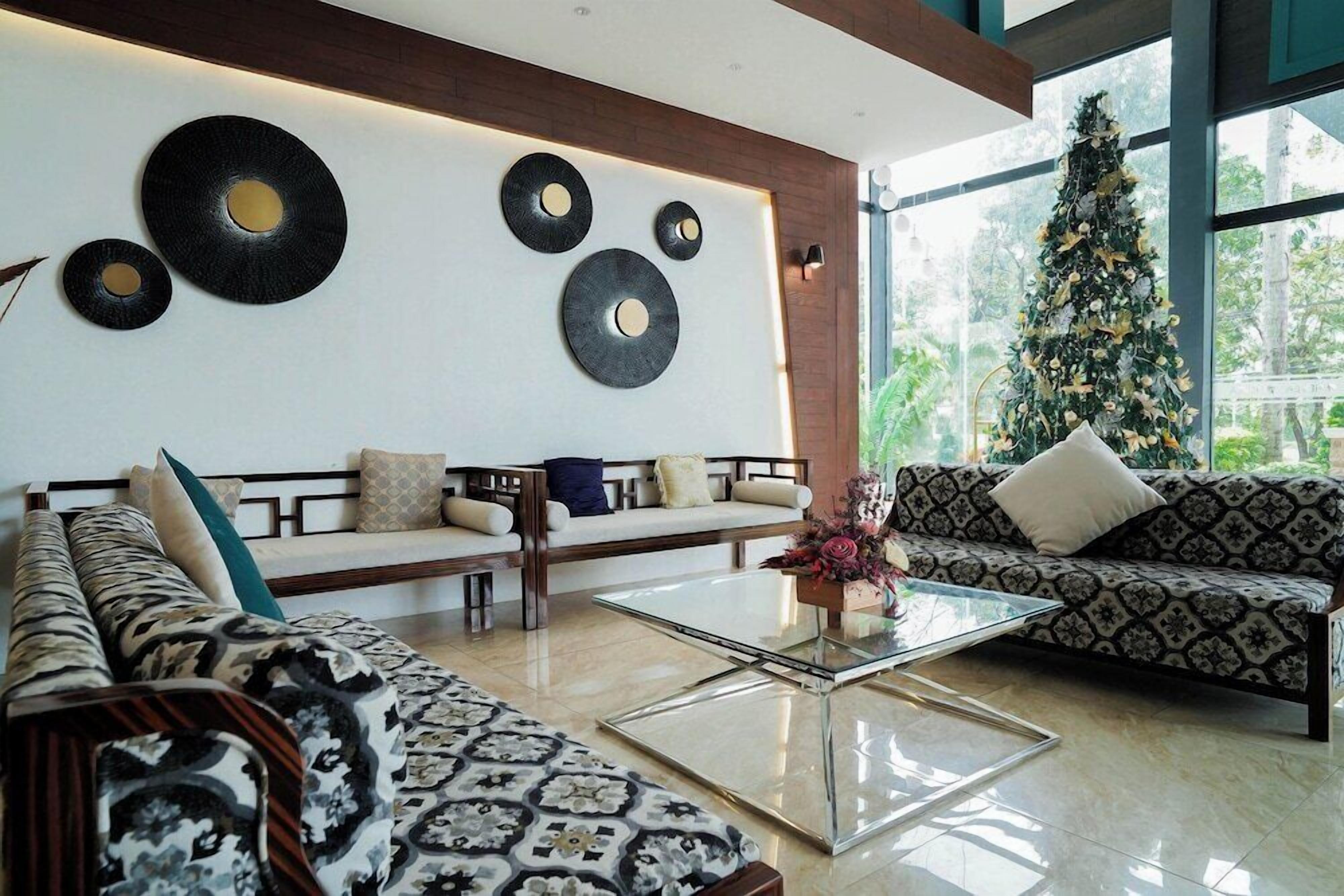 Una sala de estar moderna con un conjunto de sofá, una mesa de centro de vidrio y decoración en la pared.