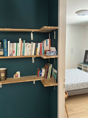Een boekenplank met verschillende boeken en een pak zakdoeken.