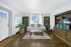 A living room with a sofa, coffee table, and bookshelves.