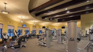 A gym with cardio machines, weight stations, and mirrors.