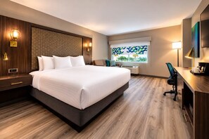 A hotel room with a large bed, a desk, a chair, and a window with a view. - Verta Hotel McAllen (McAllen)
