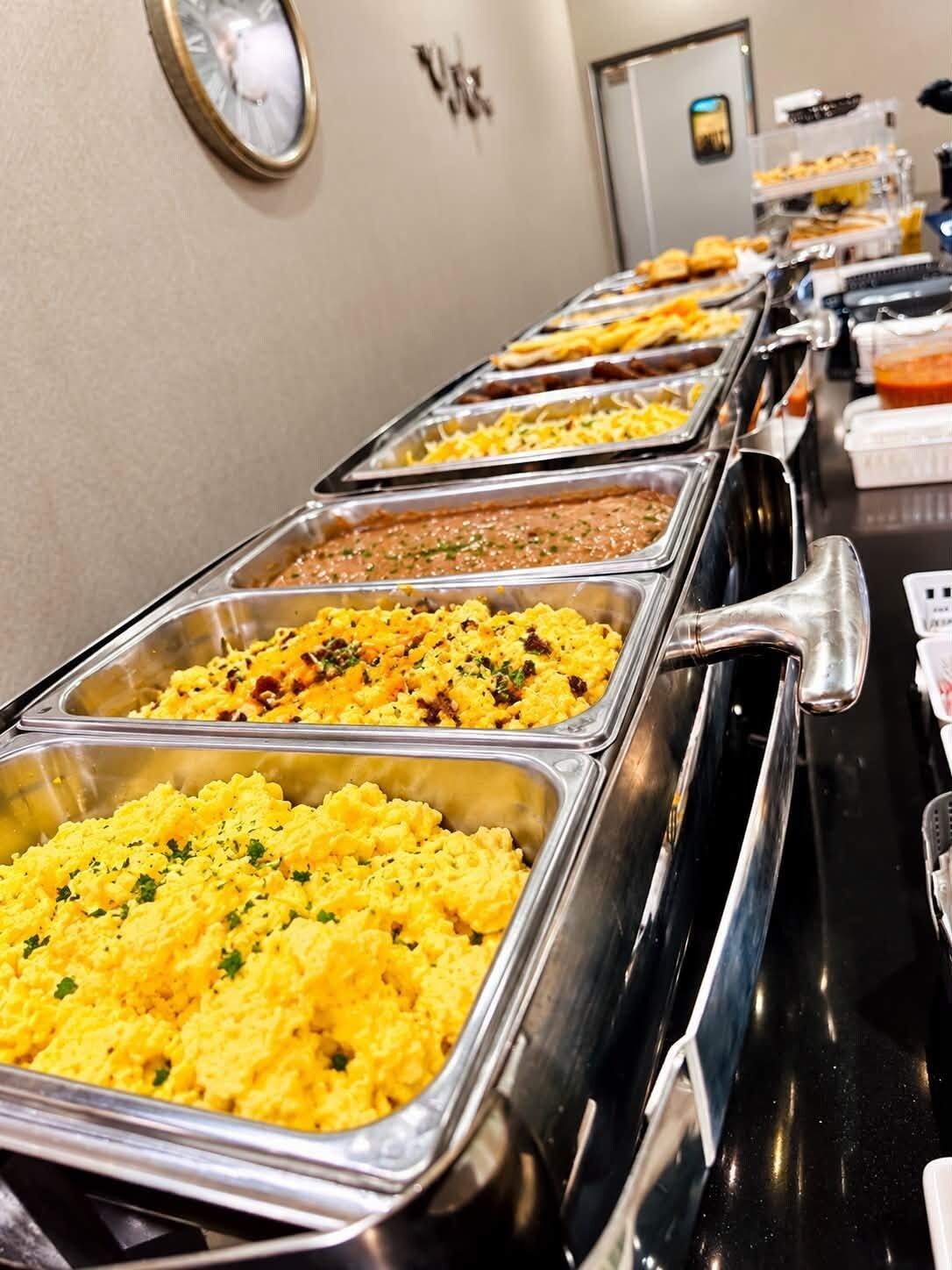 Een buffet met diverse gerechten in metalen bakken.
