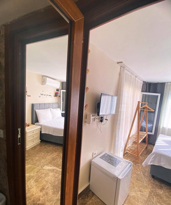 A hotel room with a bed, bedside table, and a small white appliance. - Buyukada Carsi Pansiyon (Adalar)