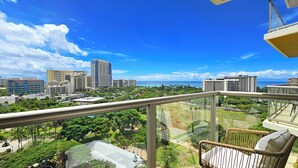 A balcony with a view of a cityscape and the ocean.