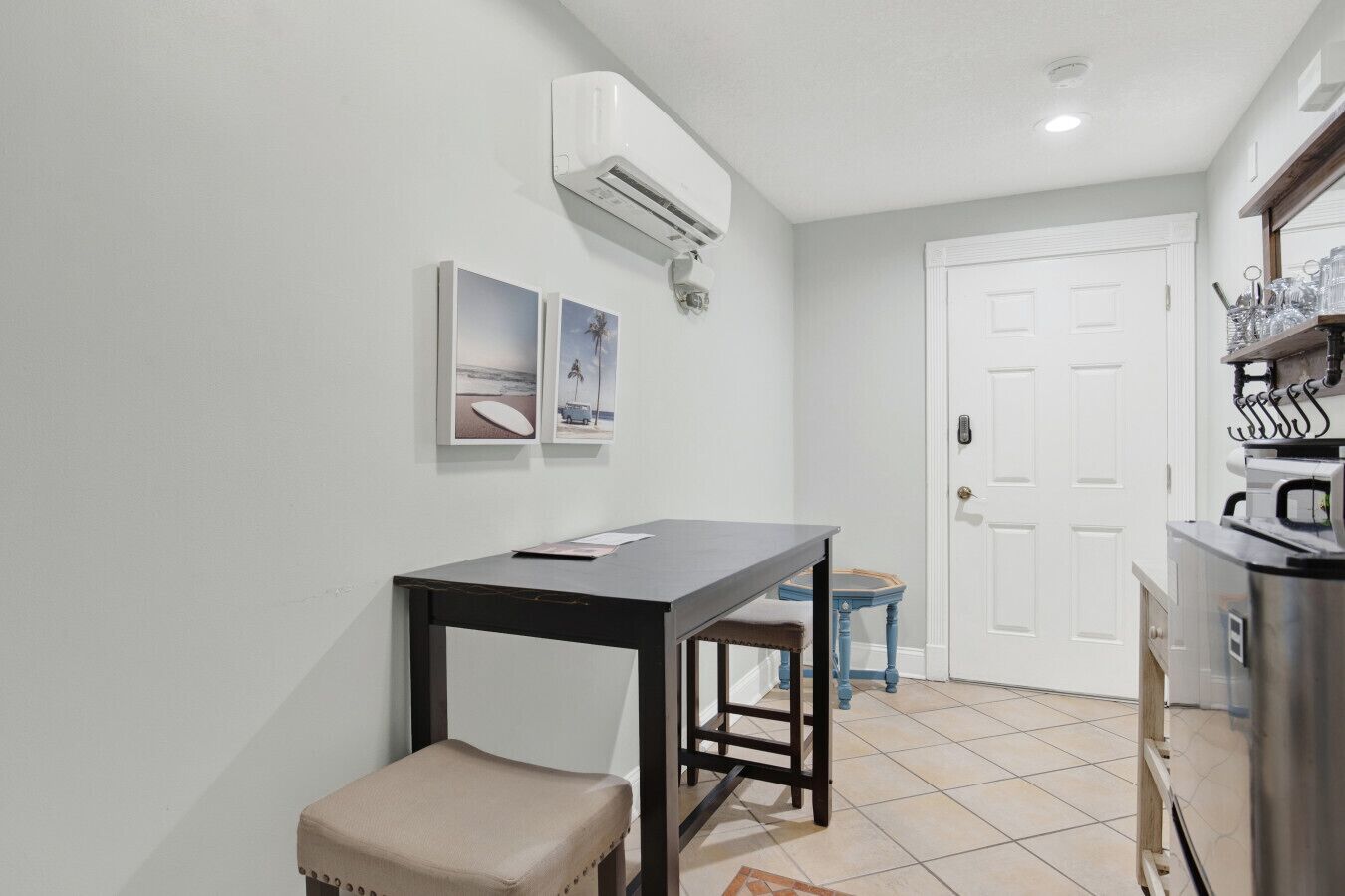 A small, clean room with a table, a bench, and a door.