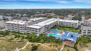 A multi-story hotel with a swimming pool and outdoor seating area. - Beachside Colony Resort Unit 222A (Tybee Island)