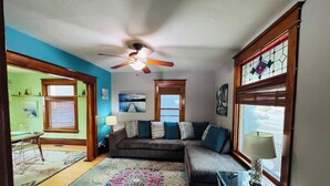 A living room with a sectional sofa, a glass coffee table, and a ceiling fan. - Charming 3 Bdrm by State Fair-Allianz Field -Como (Saint Paul)