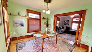 A dining area with a wooden table and chairs, a patterned rug, and a chandelier. - Charming 3 Bdrm by State Fair-Allianz Field -Como (Saint Paul)