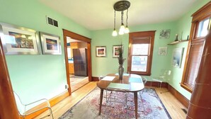 A dining area with a table and chairs, a hanging light fixture, and a patterned rug. - Charming 3 Bdrm by State Fair-Allianz Field -Como (Saint Paul)