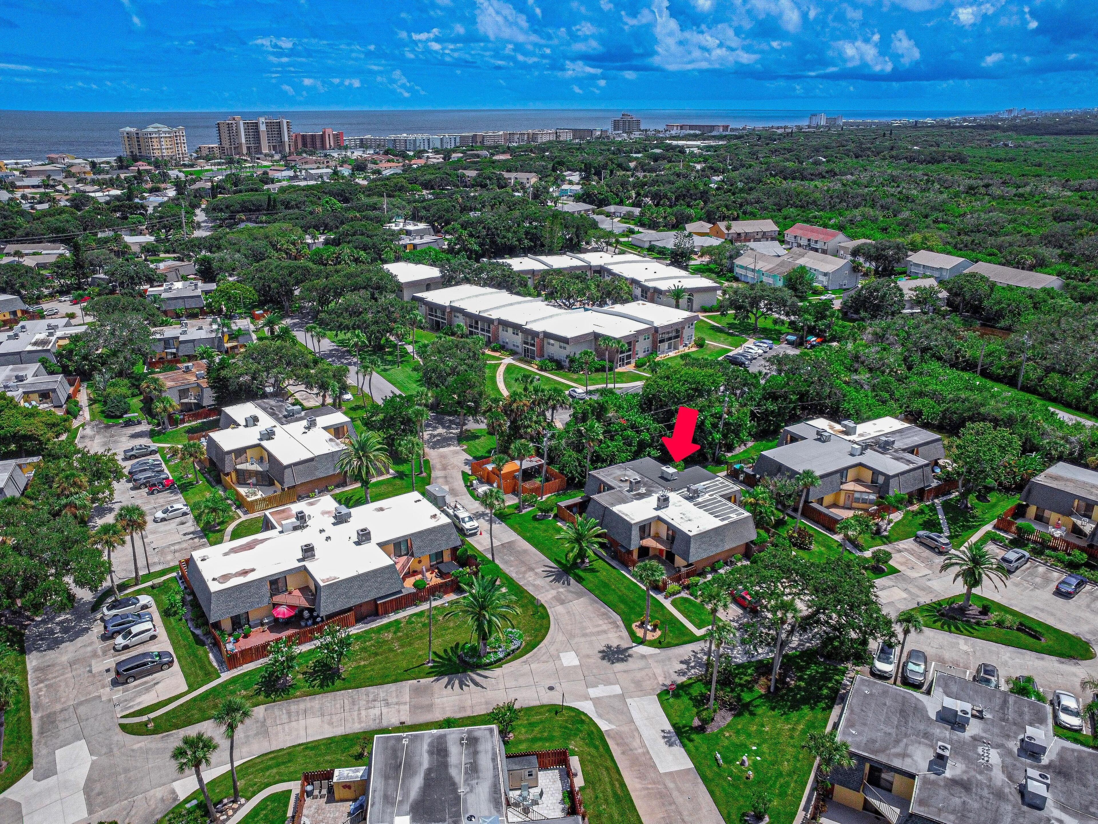 Vista aérea de una zona residencial con varios edificios, calles y vegetación.