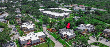 Vista aérea de una zona residencial con varios edificios, calles y vegetación.
