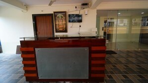 En receptionsdisk med modern design, en takfläkt och ett inramat religiöst konstverk på väggen.
