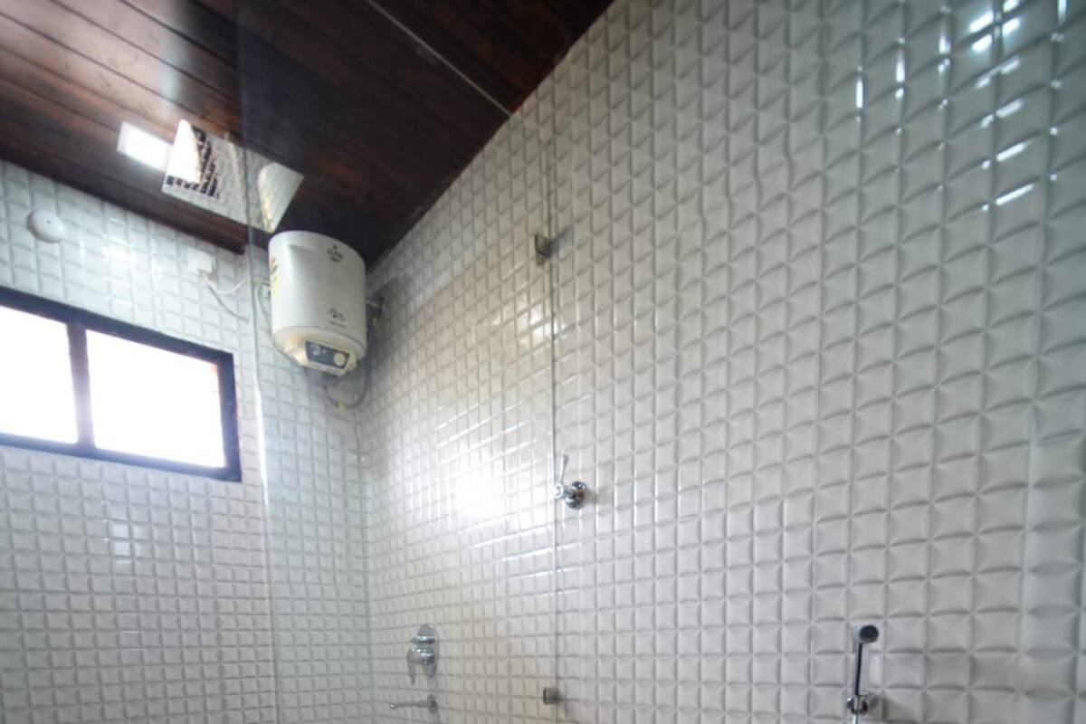 A small bathroom with a toilet, sink, and shower.