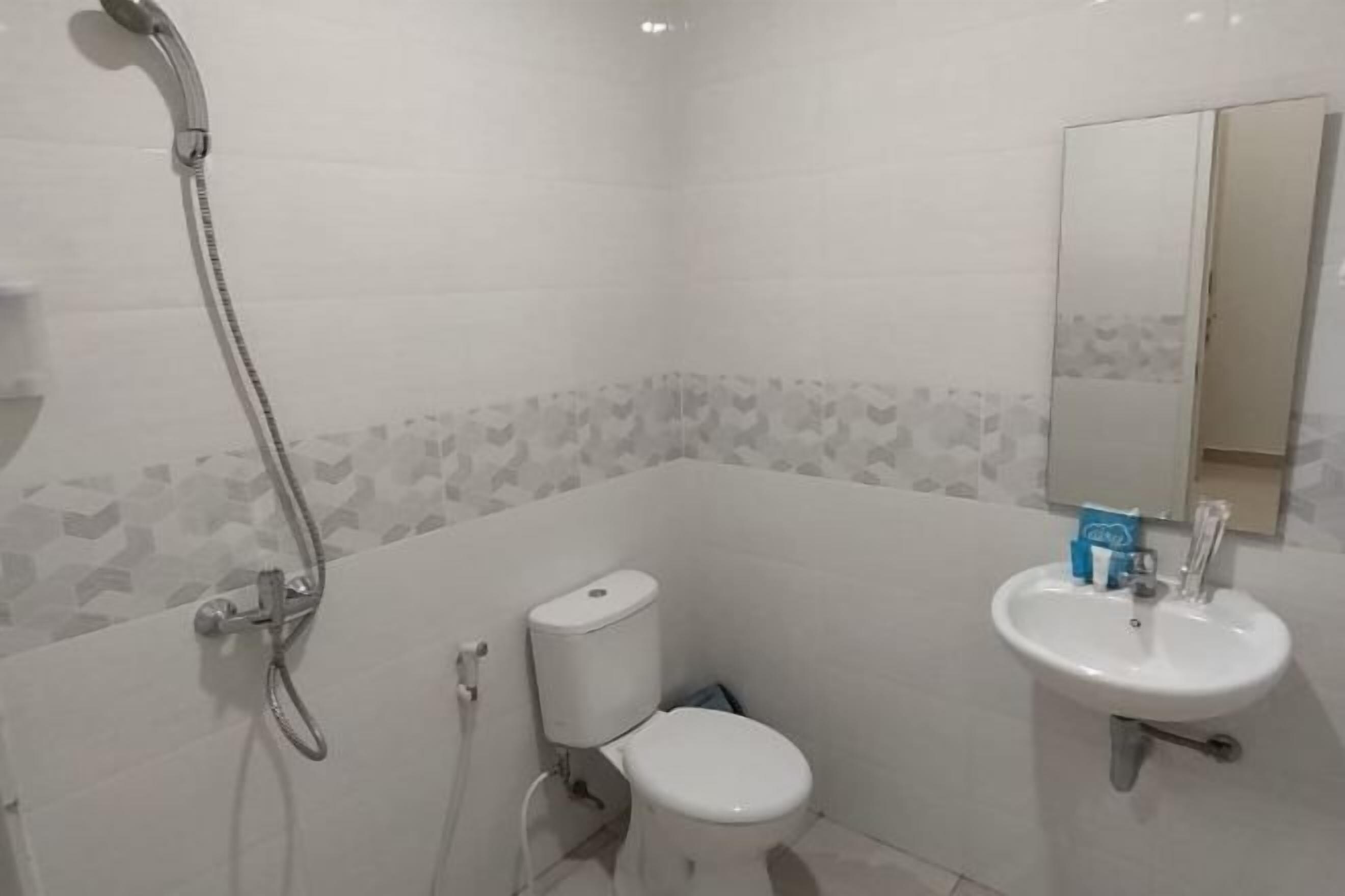 A bathroom with a toilet, sink, and shower.