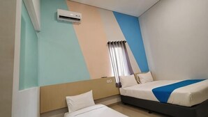 A hotel room with two beds, a window with curtains, an air conditioning unit, and a wall with a geometric design. - INNCA Telaga Bodas, Semarang (Gajahmungkur)