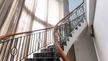 Una escalera con barandilla de madera y balaustradas de metal negro.