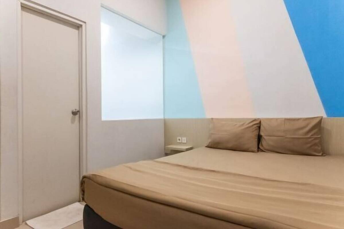 Une chambre à coucher avec un lit, une table de chevet et une porte.