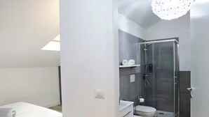 A modern bedroom with a bed, a bathroom with a shower, and a toilet. - Lovoleti Lodge (Modena)