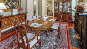 Een formele eetzaal met een houten tafel, stoelen en een kamerbreed tapijt.