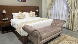 A bedroom with a bed, nightstands, a sofa, a rug, and curtains. - Casa Tanjung Jara (Kuala Dungun)