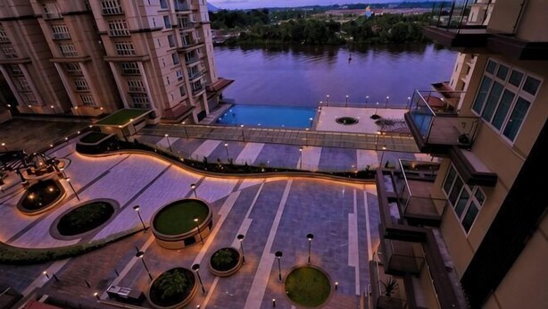 A high-rise hotel with a view of a river, outdoor seating areas, and a bridge. - Boutique Themed Studio - Kuching Riverine Diamond (Kuching)