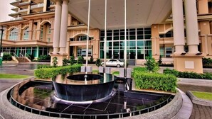 A hotel entrance with a central fountain, large columns, and a modern building facade. - Boutique Themed Studio - Kuching Riverine Diamond (Kuching)