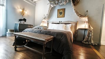 Een slaapkamer met een groot bed, een nachtkastje, een lamp en een schilderij aan de muur.
