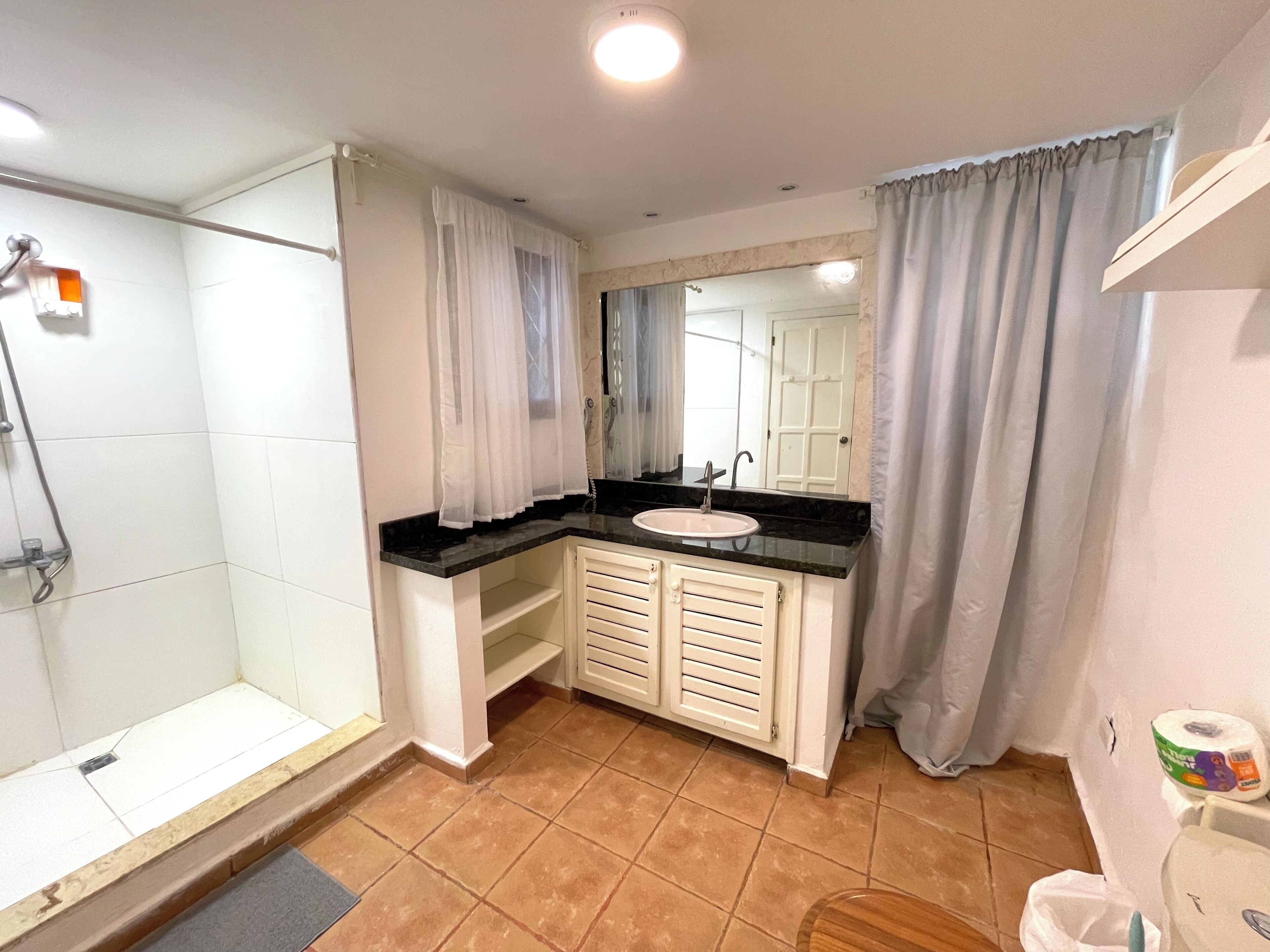 A bathroom with a shower, sink, and toilet.