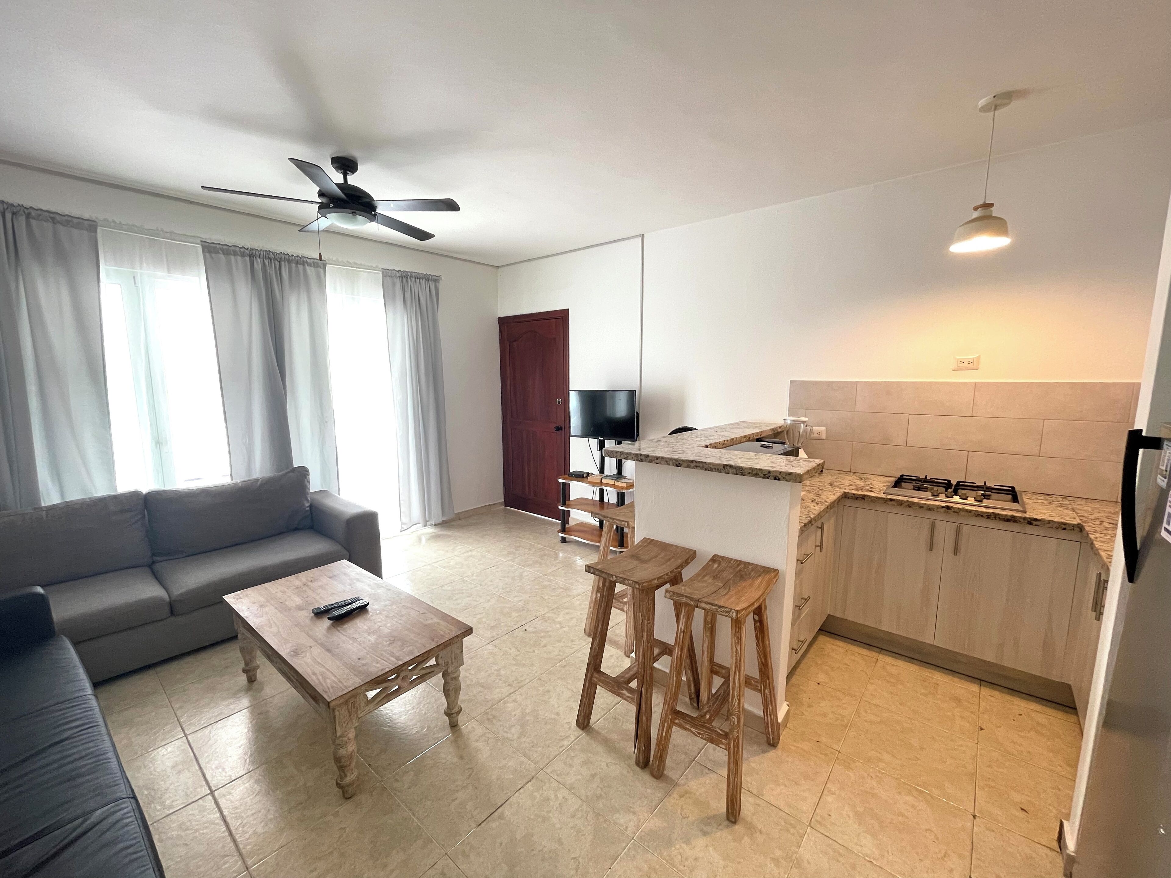 Uma sala de estar moderna com um sofá, uma mesa de centro e uma televisão.