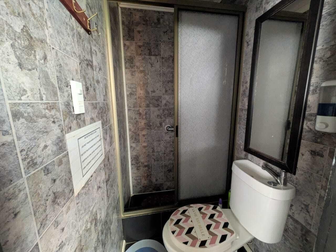 Un baño con ducha, inodoro y lavabo.
