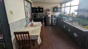 Una cocina compacta con una mesa y sillas, un refrigerador, un microondas y un lavamanos.