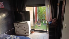 Een kamer met een schuifdeur die uitkomt op een klein buitengebied met planten.