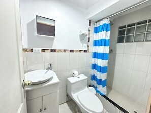 Chambre triple Confort | Salle de bain | Douche, séchoir à cheveux, savon, shampooing