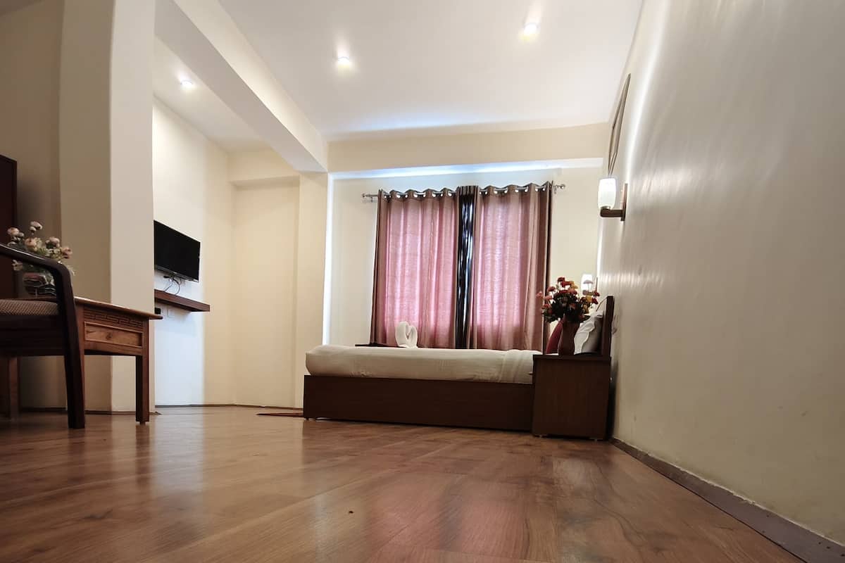 A room with a bed, a desk, and a chair.