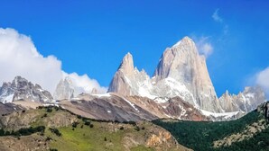 A mountainous landscape with a village and towering peaks.