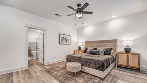 A spacious bedroom with a large bed, a ceiling fan, and a nightstand with a lamp. - Holiday Hills Getaway! (Counce)