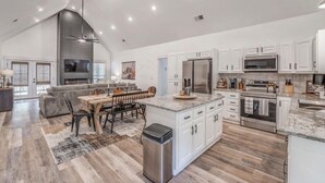 A spacious kitchen with white cabinets, a granite countertop, and stainless steel appliances. - Holiday Hills Getaway! (Counce)