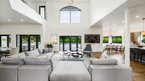 A spacious living area with a sectional sofa, a coffee table, and a dining area with chairs and a table. - Villa Rio Grande 8BR Lazy River Pool + Pickleball (Miami)