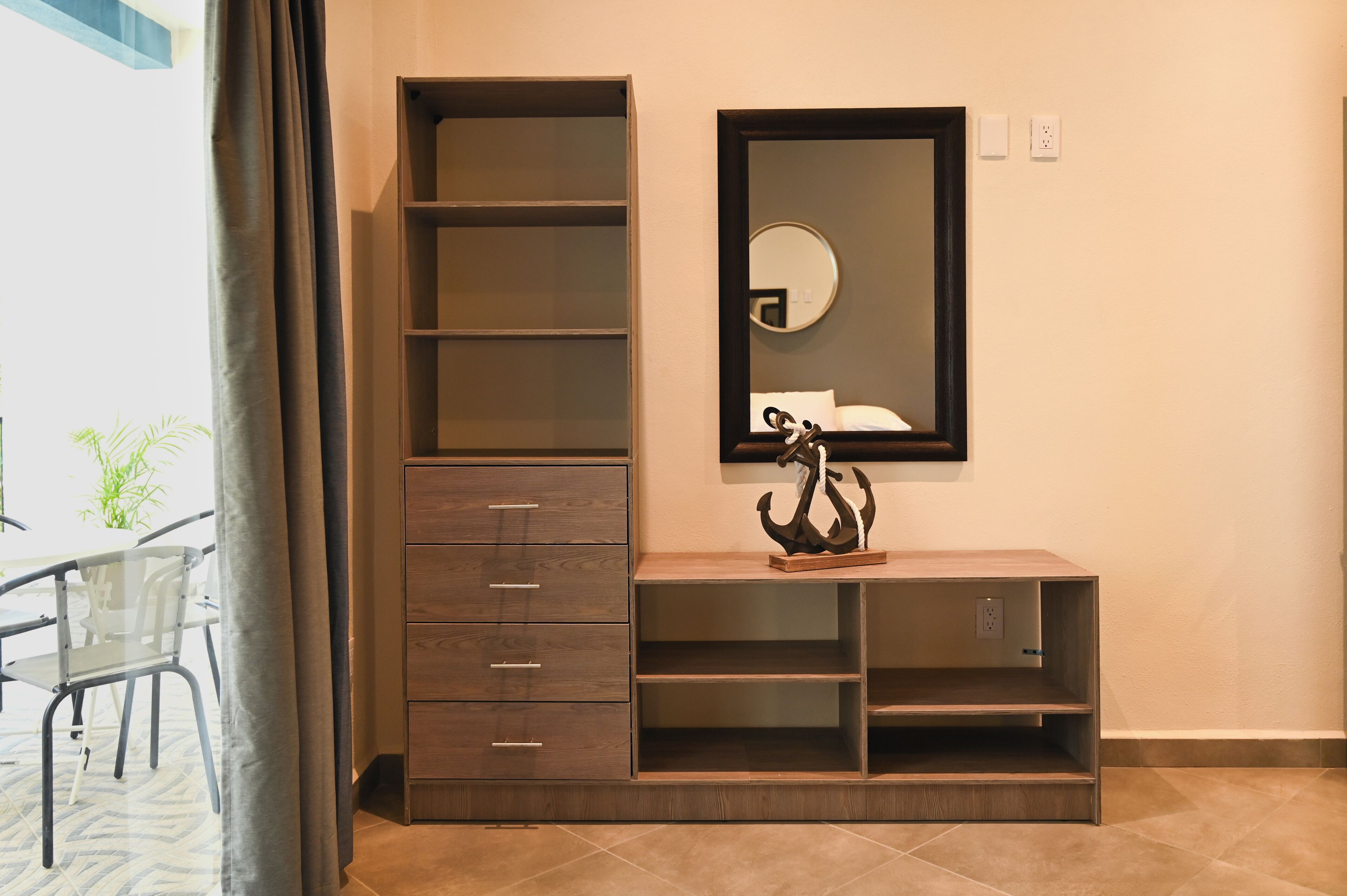 A modern room with a built-in wooden cabinet, a mirror, and a small statue on a shelf.