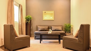 A living room with two armchairs, a sofa, a coffee table, and a mirror on the wall. - Casa Coral (Sayulita)