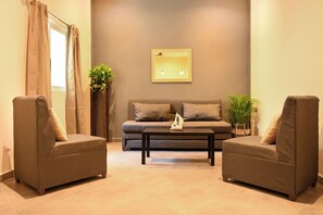 Condo superior, vista a la ciudad | Área de sala de estar | Televisión de 55 pulgadas con canales digitales