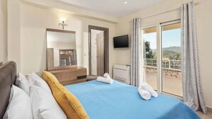 Une chambre d’hôtel comprenant un lit, une télévision, un balcon avec vue et une porte donnant sur la salle de bain.