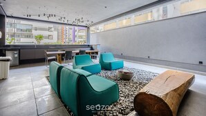 A modern interior with seating, a wooden table, and a view of the cityscape. -  Studio w/ pool near subway FRE2112 (São Paulo)