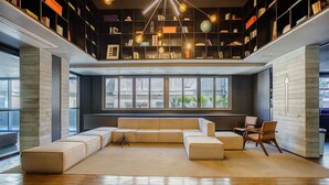 A modern living room with a sectional sofa, a coffee table, and a bookshelf filled with books and decorative items. -  Studio w/ pool near subway FRE2112 (São Paulo)