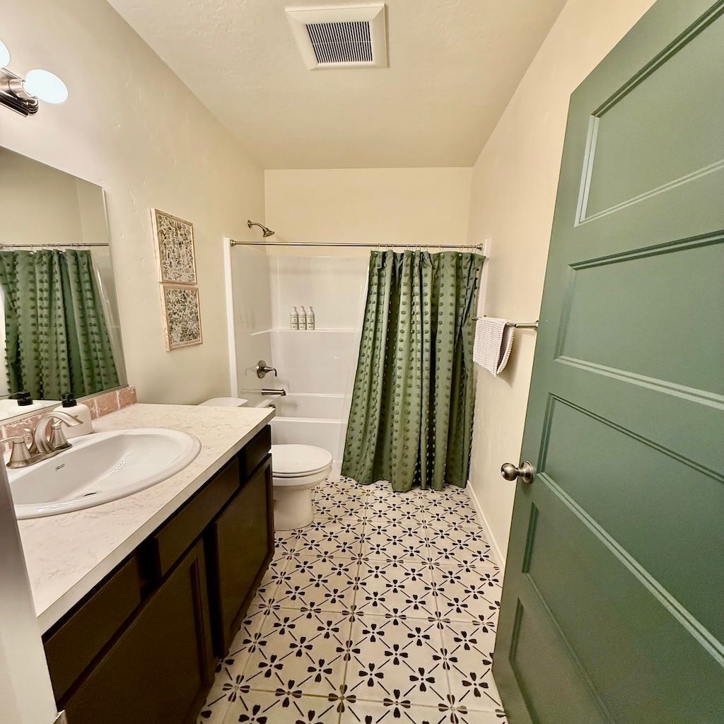 A bathroom with two sinks, a toilet, and a shower.