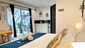 A hotel room with a bed, a desk, and a view of the outside balcony. - Ocean Lovers Taganga Dive Center& Hostel (Taganga)